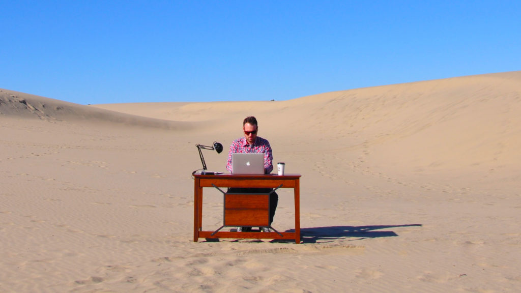 Location Rebel founder Sean Ogle working at his desk in the desert.